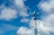 Telecommunication tower with blue sky and white clouds. Antenna on blue sky. Radio and satellite pole. Communication technology.