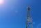 Telecommunication tower or mast with microwave, radio panel antennas, outdoor remote radio units, power cables, coaxial