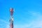 Telecommunication tower with signal repeater antennas against blue sky