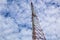 Telecommunication towers, large high-rise steel, sky background and clouds