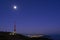Telecommunications antenna with full moon on Mount Jaizkibel and San Sebastiian city in background