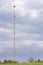 The telecommunications tower, located at the top of the hill, rises in the sky against the blue sky.