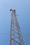 Telecommunications tower, microwave telecom antenna seen from below, isolated against a blue sky