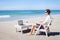 Telecommuting, businessman with laptop on the beach