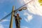 A telecoms worker is shown working from a utility pole ladder while wearing high visibility personal safety clothing, PPE, and a