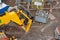 Telehandler on construction site moving heavy steel box full of scaffolding parts