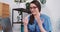 Telemedicine concept. Happy young healthcare professional woman in blue scrubs consults patient online via laptop webcam