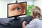 Telemedicine eye doctor observes eyelid cyst on computer