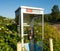 A telephone booth covered with foliage at a gas station in canada