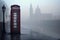 telephone booth on a foggy london morning with tower bridge behind