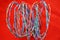 Telephone or computer network cable twisted pair twisted into a spiral. On red background.