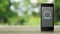 Telephone and email flat icon on modern smart mobile phone screen on wooden table over blur green tree in park, Business contact u