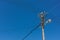 Telephone lamp pole with electrical wires against blue sky