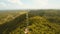 Telephone signal tower among green forest and mountains. Aerial view. Siargao island Philippines.