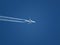 Telephoto view of passenger jet flying at cruising altitude on a blue sky background