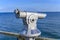 Telescope with coin slot on the pier in Bansin on the island of Usedom in Germany. Sea and sky are dark blue and radiate