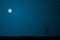 Telescope on starry night sky with blue glow.