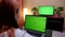 Television computer green screened woman - full HD. woman watches television and uses computer with green screen shot