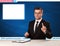 Television reporter telling breaking news at his studio desk with copy space