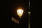 The Television Tower in downtown Berlin at night. In the foreground is a historic Berlin lantern with a historic street sign on wh