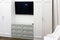 A television between two white cabinets. Laconic interior design