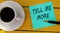 TELL ME MORE - words on a green sheet on a yellow wooden background with a pen and a cup of coffee