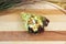 Temaki Sushi Unagi eel Hand Roll wrapped Mamenori seaweed served on wooden board with plant on background