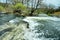 Tempestuous river with small stone rapids