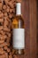 Template of white glass bottle of wine on corks and wood background. Poster concept design photo shooting