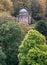 Temple of Apollo surrounded by trees and shrubs overlooking the lake at Stourhead National Trust property. Wiltshire UK