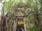 Temple covered with Banyan Tree roots, Luang por Nil Manee banner in the front door of Wat Bang Kung temple, Samut Songkhram,