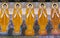 Temple painting, Hsipaw, Myanmar,row of Buddha figures in yellow robes