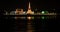 Temple and white pagoda on river bank at night