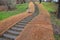 Temporary covering of the lawn sowing fabric to ensure a large slope against erosion. Along the wooden stairs. using a brown jute