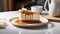 a tempting caramel Biscoff cheesecake displayed on a white table, accompanied by a slice and a cup of tea or coffee,the