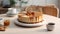 a tempting caramel Biscoff cheesecake displayed on a white table, accompanied by a slice and a cup of tea or coffee,the