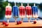 A tempting lineup of popsicles adorned with vibrant red, white, and blue toppings., Red, white, and blue popsicles on an outdoor