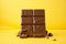Tempting sweetness milk chocolate bar on yellow background, indulgent delight