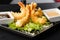 Tempura Deep Fried Shrimp Ebi with sweet chili and soy sauce on black board stone on dark background. Japanese food style