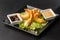 Tempura Deep Fried Shrimp Ebi with sweet chili and soy sauce on black board stone on dark background. Japanese food style