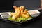 Tempura Deep Fried Shrimp Ebi with sweet chili and soy sauce on black board stone on dark background. Japanese food style