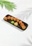 Tempura sushi roll with grapefruit and mango sauce. Hot maki sushi in black plate on white background. Summer menu for japanese