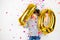 Ten birthday party girl with golden balloons and confetti