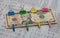 Ten-dollar bill, multi-colored paper clips and clothespins on a newspaper background, obligations, trend