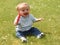 Ten month old baby boy eating a lolly outdoors