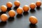 Ten upscale golden chicken eggs lie on a gray, rough rustic table. Selective focus