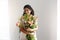 Tender african girl florist smiling holding bouquet of alstroemerias over white wall. Closed eyes.