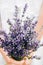 Tender bows of a girl holding a bouquet of lavender