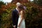 Tender bride stands behind a groom with closed eyes in the front