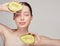 Tender brown-haired lady with with avocado on top and bottom in hands